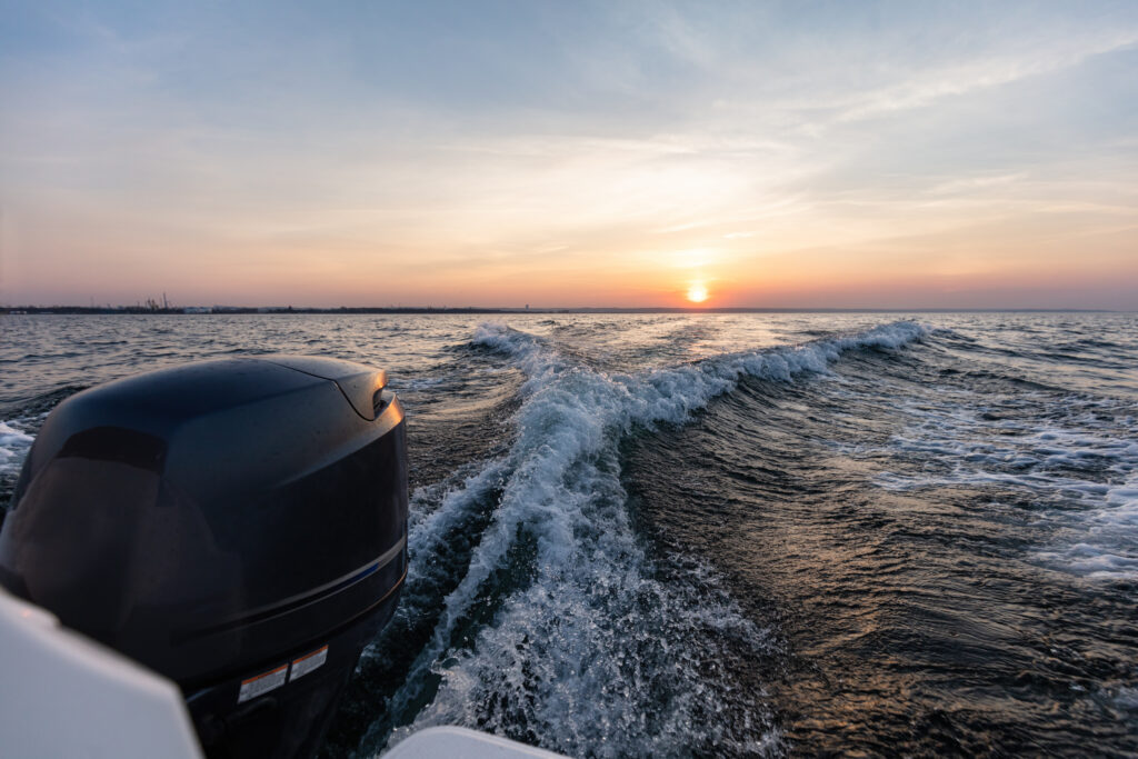 Fast motorboat ride on sea at sunset.
