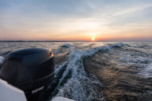 Fast motorboat ride on sea at sunset.
